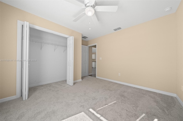 unfurnished bedroom with a closet, light colored carpet, and ceiling fan