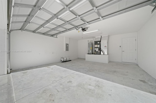 garage featuring electric panel, a garage door opener, heating unit, and water heater