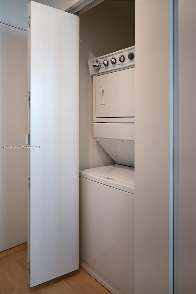 laundry area featuring light hardwood / wood-style flooring and stacked washer / drying machine