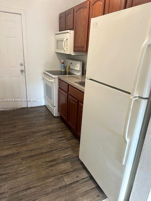 kitchen featuring dark hardwood / wood-style flooring and white appliances