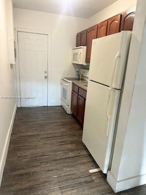 kitchen with dark wood-type flooring and white appliances