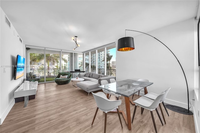 dining area featuring light hardwood / wood-style floors and a wall of windows