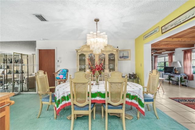 dining space with tile patterned floors, a notable chandelier, a textured ceiling, and visible vents