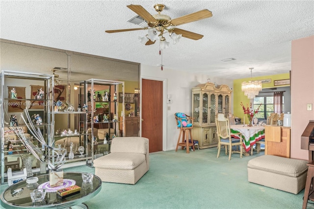 carpeted living room with a textured ceiling and ceiling fan with notable chandelier