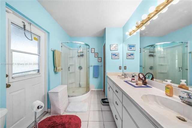 bathroom featuring a sink, a shower stall, tile patterned floors, and double vanity