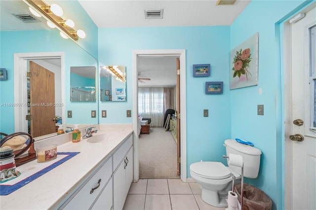 ensuite bathroom with tile patterned floors, visible vents, and vanity