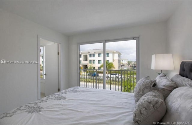 bedroom with access to exterior and a water view