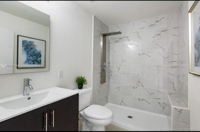 bathroom featuring vanity, toilet, and a tile shower