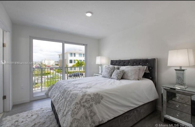 bedroom featuring wood-type flooring and access to outside