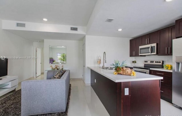 kitchen with light tile patterned floors, a center island, stainless steel appliances, and sink