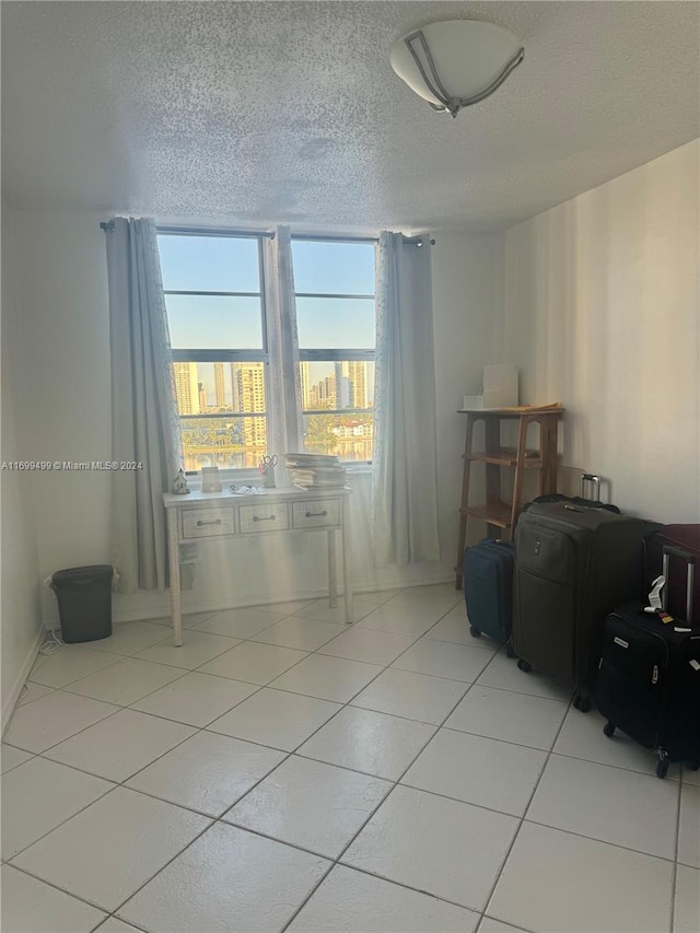 tiled spare room with a textured ceiling