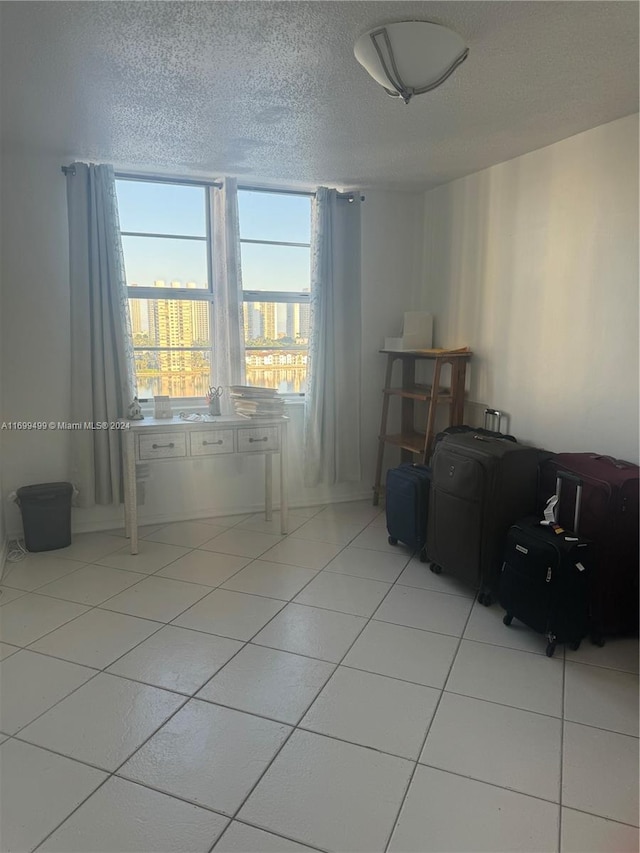 spare room with light tile patterned flooring and a textured ceiling