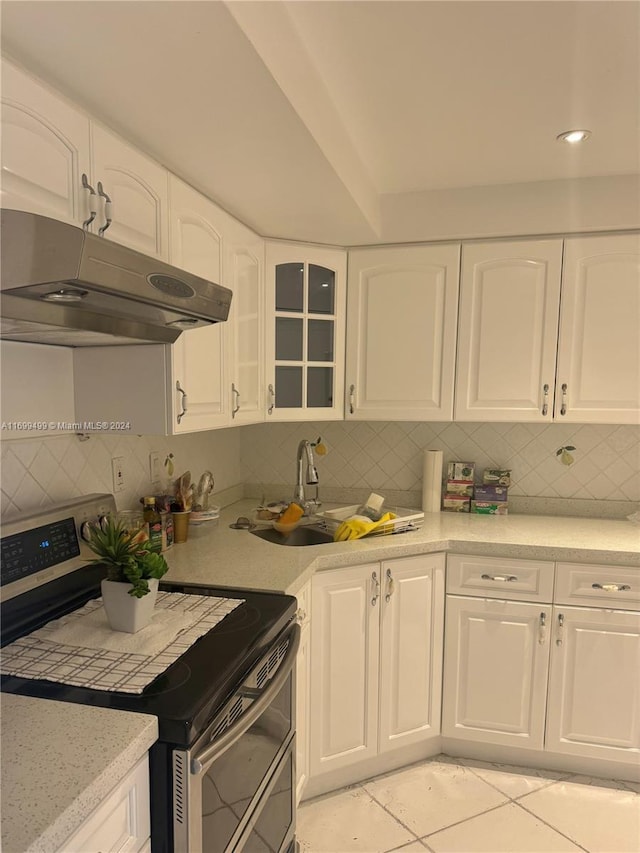 2750 NE 183rd St Unit 1210, Aventura, FL 33160 - kitchen featuring stainless steel electric range oven, exhaust hood, decorative backsplash, and white cabinetry
