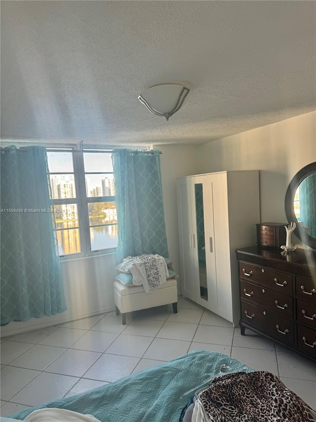 tiled bedroom with a textured ceiling