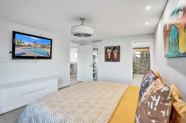 bedroom with light hardwood / wood-style flooring and connected bathroom