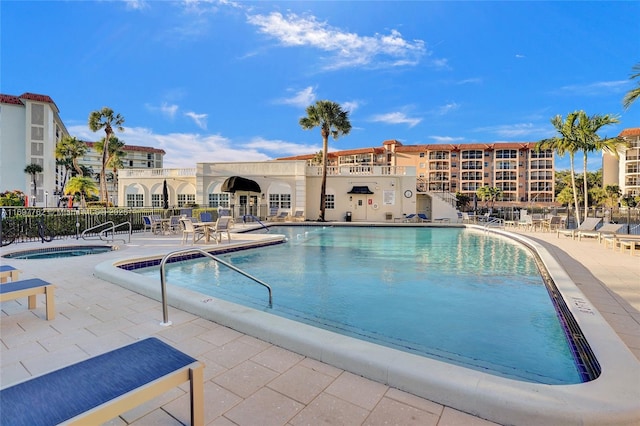 view of swimming pool featuring a hot tub and a patio