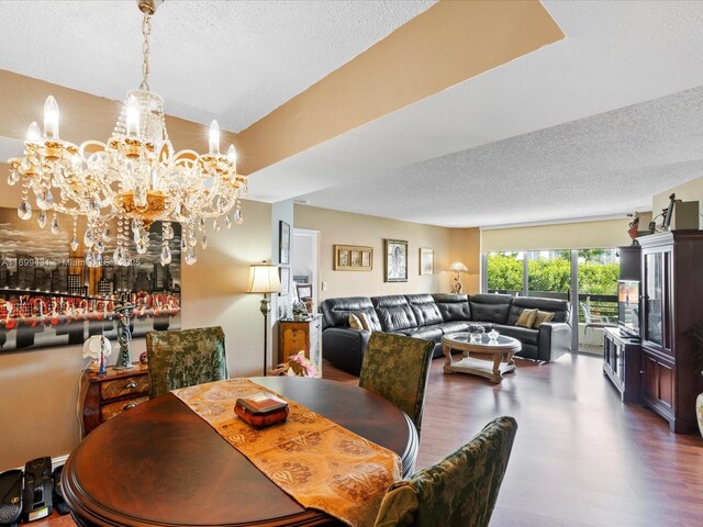 dining area with a textured ceiling, a chandelier, and wood-type flooring