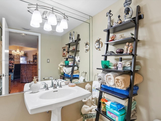 bathroom with sink and an inviting chandelier