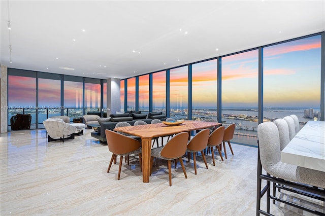 dining space with floor to ceiling windows and a water view