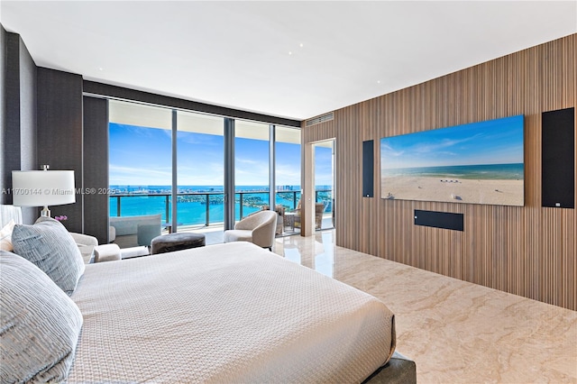 bedroom featuring wood walls, floor to ceiling windows, and access to outside