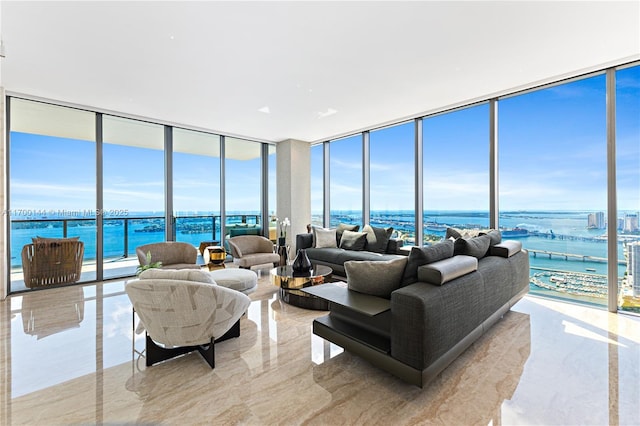 living room featuring expansive windows, marble finish floor, and a water view