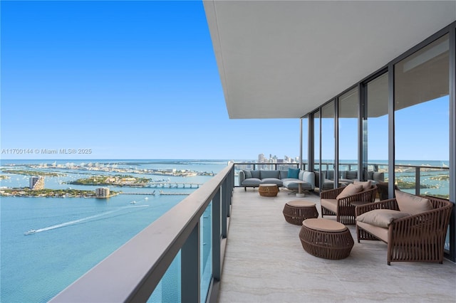 balcony featuring a water view and an outdoor living space