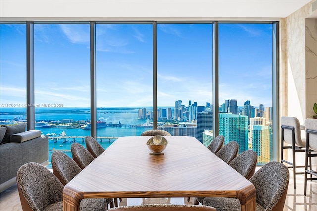 dining space with a water view, expansive windows, and a view of city