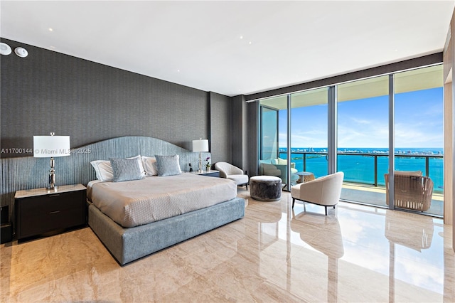 bedroom featuring floor to ceiling windows, a water view, and access to outside