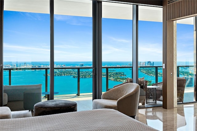 bedroom featuring a wall of windows and a water view