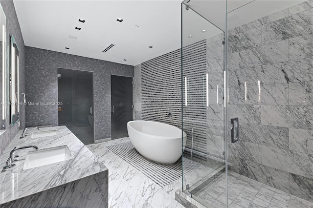 full bathroom with a soaking tub, a sink, marble finish floor, and a marble finish shower