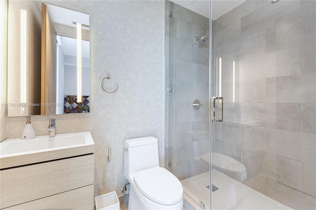 bathroom featuring a shower with door, vanity, and toilet