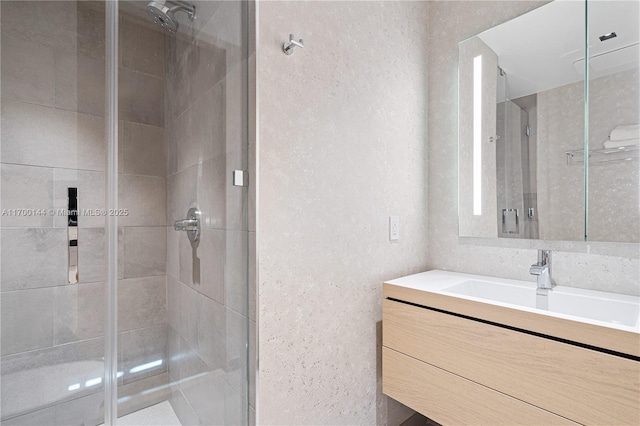 bathroom with vanity and a shower with shower door