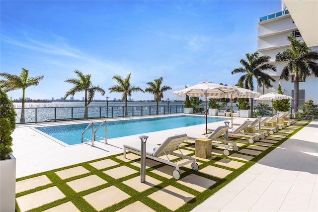 view of pool featuring a patio and a water view