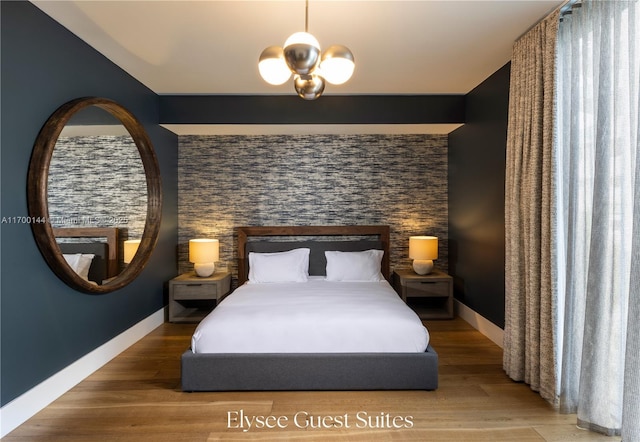 bedroom featuring hardwood / wood-style floors and a chandelier