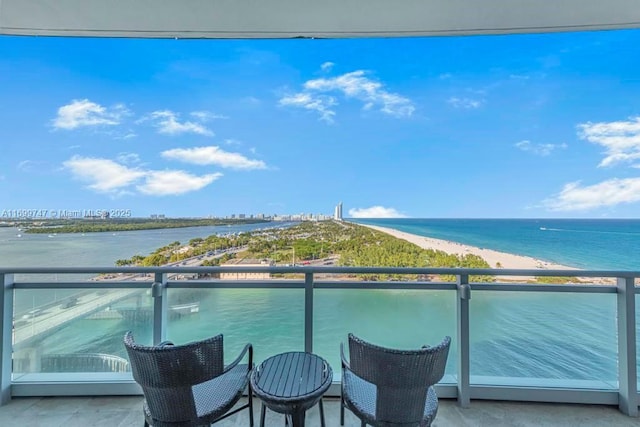 balcony featuring a water view and a view of the beach