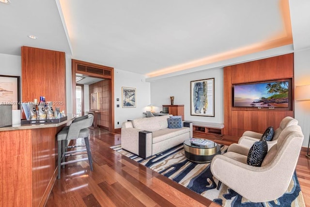 living room featuring dark hardwood / wood-style flooring and bar