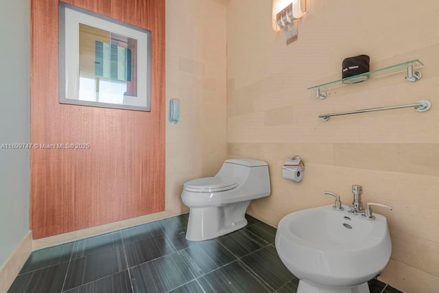 bathroom featuring toilet and a bidet