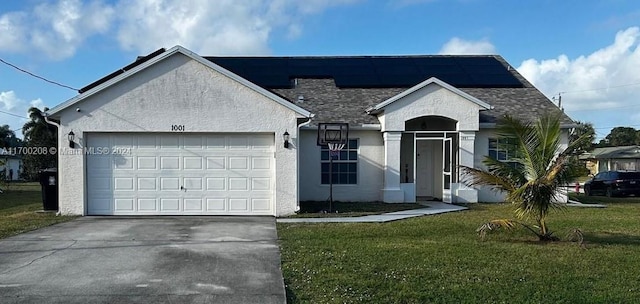 ranch-style home featuring a front yard, solar panels, and a garage