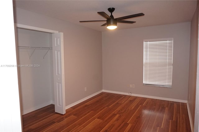 unfurnished bedroom with ceiling fan, a closet, and dark hardwood / wood-style floors