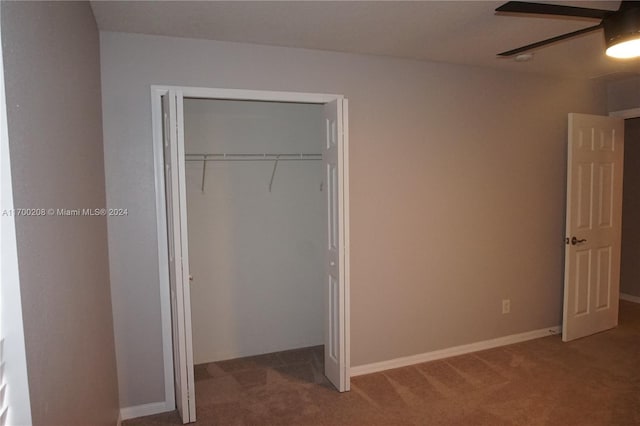 unfurnished bedroom featuring ceiling fan, a closet, and carpet