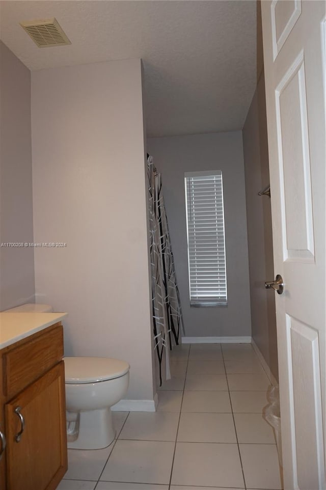 bathroom featuring tile patterned flooring, vanity, and toilet