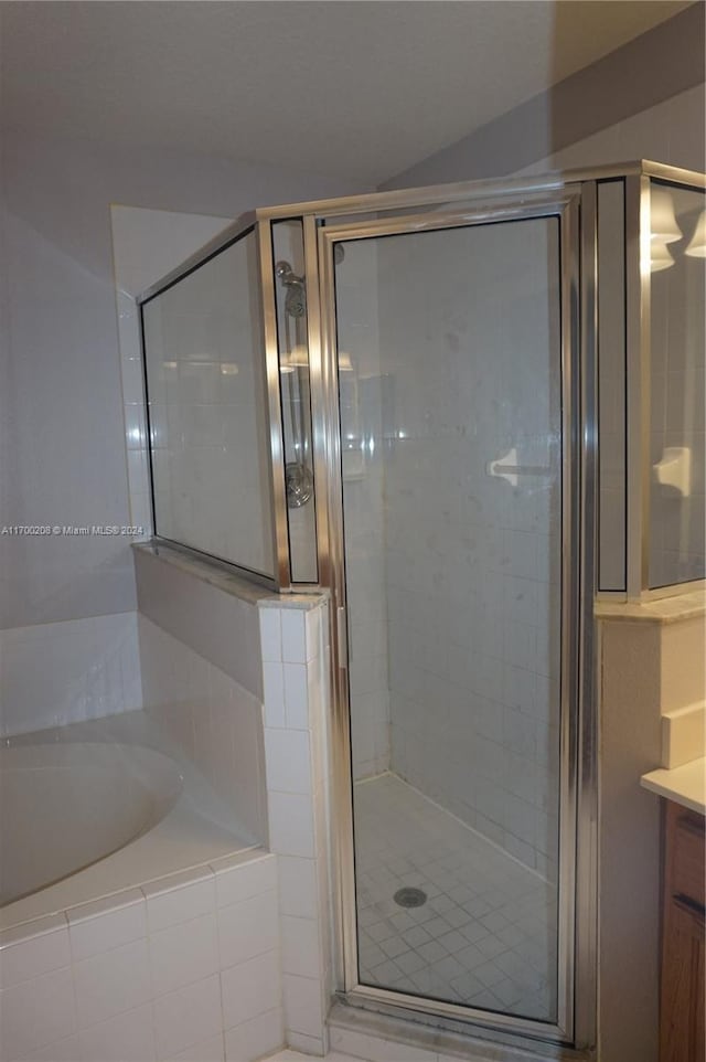 bathroom featuring vanity and shower with separate bathtub