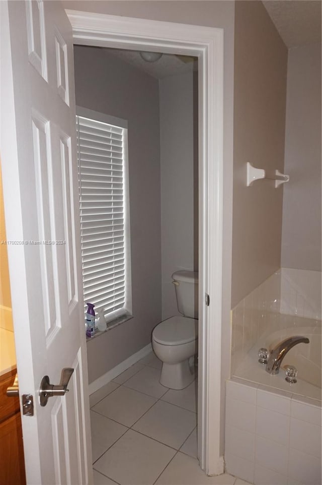 bathroom with tile patterned floors, toilet, a bathing tub, and vanity