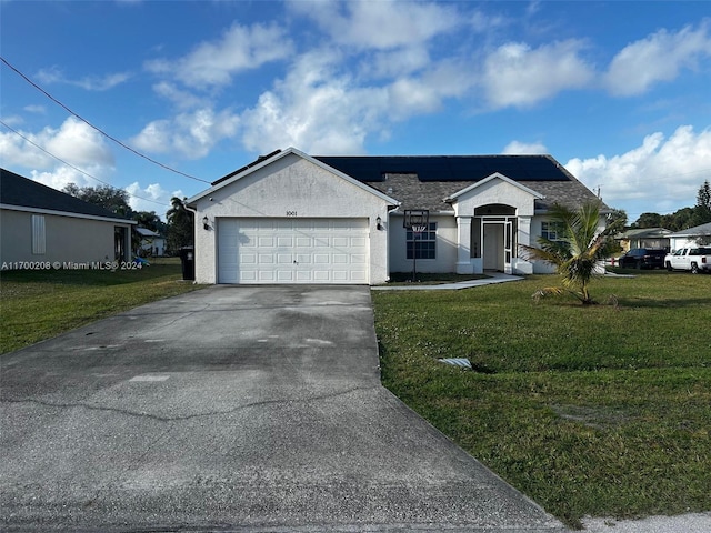 view of front of house with a garage, a front yard, and solar panels