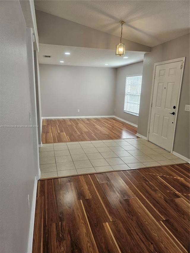 tiled empty room with lofted ceiling