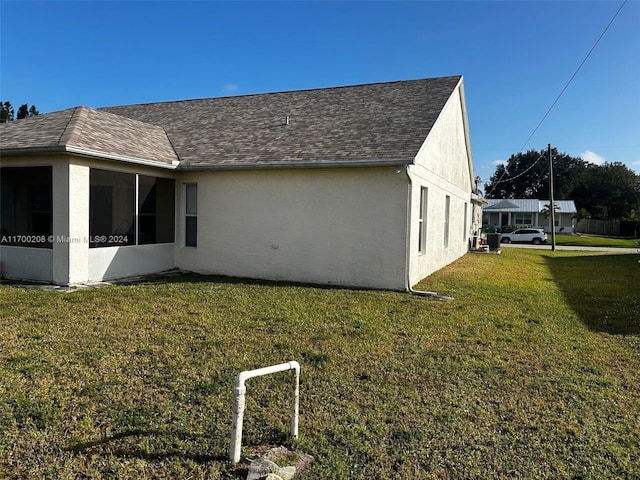 view of home's exterior featuring a sunroom and a yard