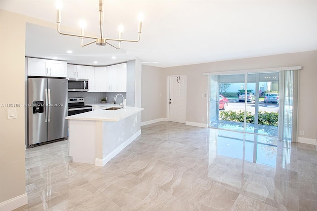 kitchen featuring an inviting chandelier, white cabinets, sink, decorative backsplash, and appliances with stainless steel finishes