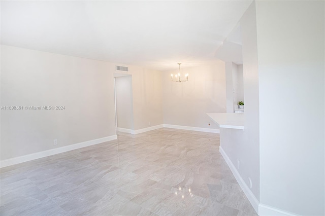 unfurnished room with an inviting chandelier