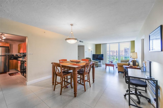 dining area with light tile patterned flooring and a textured ceiling