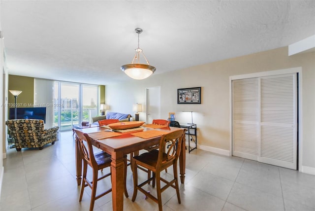 tiled dining room featuring a textured ceiling and floor to ceiling windows